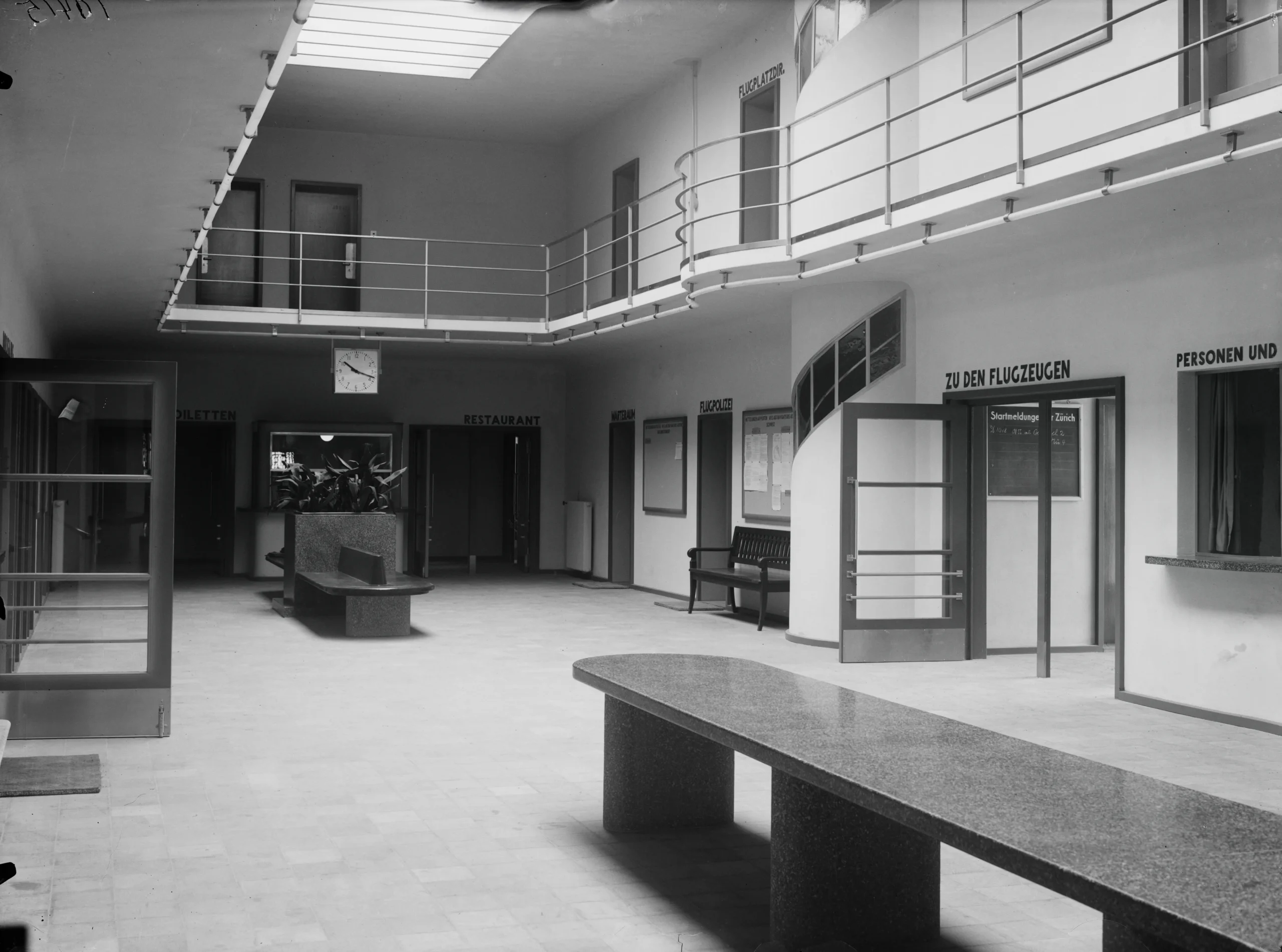 Empfangsraum mit Durchgang zum Flugfeld: «Zu den Flugzeugen», um 1934. ETH-Bibliothek Zürich, Bildarchiv/Stiftung Luftbild Schweiz